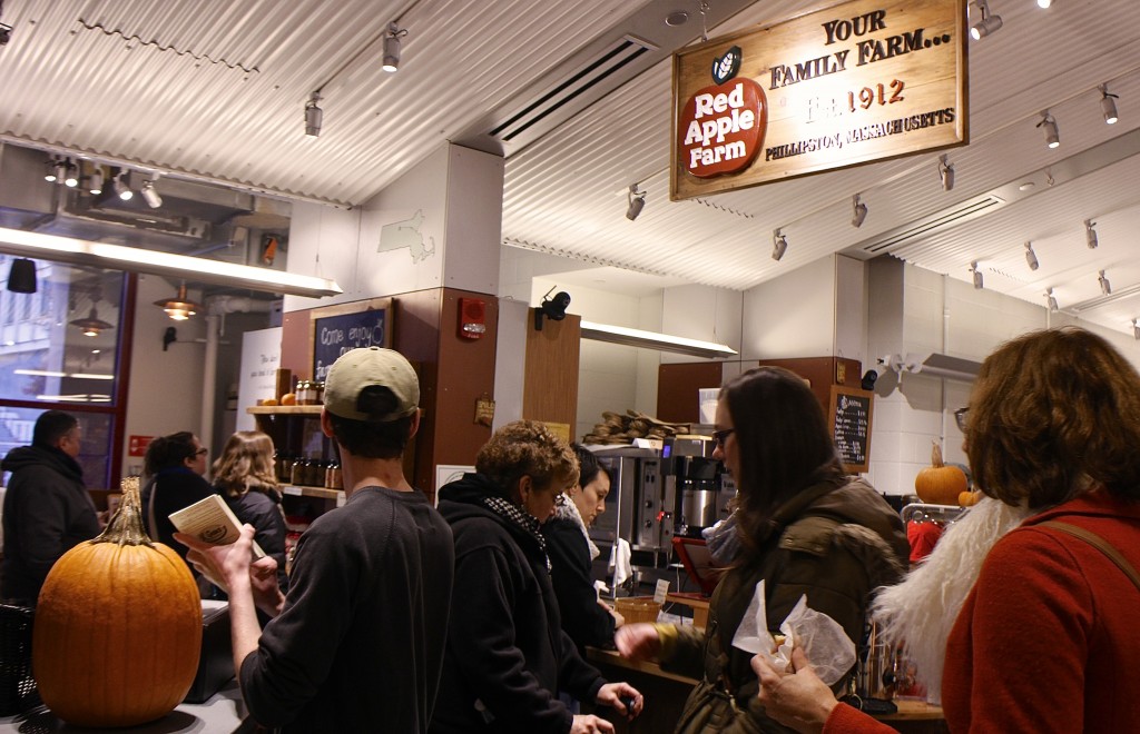 Crowds enjoying homemade cider donuts linger around the Public Market’s Red Apple Farm stall. Photo by Rebecca Jahnke.