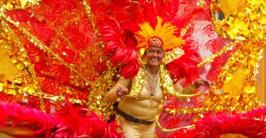 Member of the Caribbean Carnival Association displays her costume at the Columbus Day Parade in East Boston, on Sunday, Oct. 7. Photo by Flaviana Sandoval / BU News Service