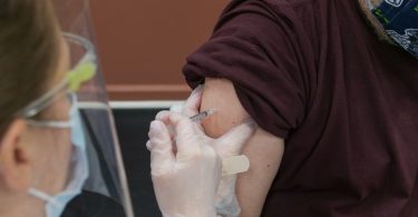 person in brown long sleeve shirt with white bandage on right hand