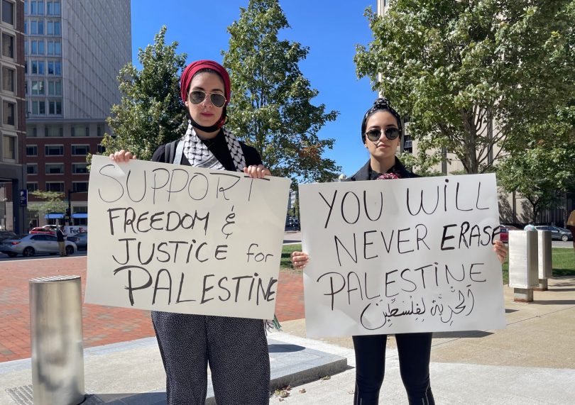 Palestinian protestors pose with posters